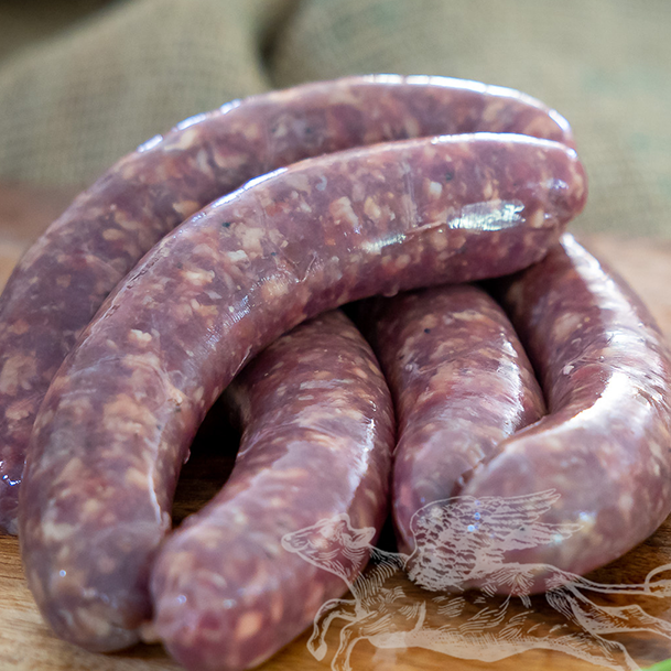 Raw sausages on a wooden cutting board with a blurred background