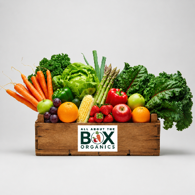 Wooden crate filled with fresh produce including carrots, lettuce, and apples, with 'All About The Box Organics' logo.