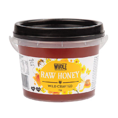 A tub of The Whole Foodies Raw Honey on a white background. 